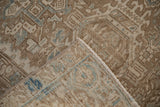 Folded corner of vintage Heriz carpet revealing machine-bound side and worn Karaja panels.