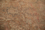 Distressed vintage Heriz carpet texture with faded geometric motifs and dusty rose.