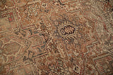 Distressed vintage Heriz carpet detail with geometric arabesques, faded chestnut, charcoal, and dusty rose.
