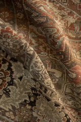 Distressed Heriz rug fold with faded geometric arabesques, faint foundation, and chocolate, rust, silver tones.