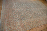 Angled view of a vintage Tabriz carpet's time-softened Herati pattern and muted terracotta border.