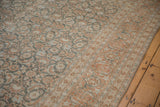 Close-up on the distressed Tabriz rug's Herati field meeting the complex Samovar Turtle border.