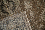 Folded corner of the vintage Heriz rug reveals its hand-knotted foundation and low wool pile.