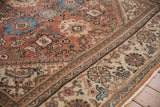 Faded brick red field, sky blue palmettes, and beige border of a vintage Mahal carpet.