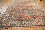 Fringe and ivory border with faded floral patterns and visible pile texture.