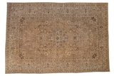 A distressed vintage Tabriz carpet with a central medallion and a floral field in muted brown and beige tones.
