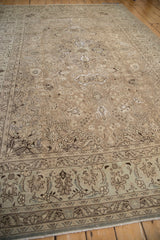 A long view of a distressed Tabriz carpet, showing the low-pile texture and scrolling corner spandrels.