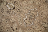 Low-pile texture of a distressed Tabriz carpet with pale coffee brown and platinum floral details.