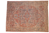 Vintage distressed Heriz carpet with a concentric medallion design in faded cherry red, sapphire blue, and ivory.
