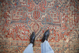 Overhead view of a distressed Heriz carpet showing the Samovar Turtle border and time-softened texture.