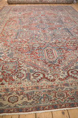 Angled view of the intricate geometric design and time-softened pile on a vintage Heriz carpet.