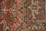 Distressed Mehrivan rug detail: dusty brick red field, geometric blossoms, and Samovar Turtle border.