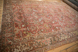 Distressed Mehrivan carpet detail: Samovar Turtle border and faded red field with geometric blossoms.