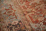 Distressed Mehrivan carpet detail: brick red field with geometric vines and oxidized silver border.