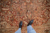 Detailed view of a distressed Ahar carpet's worn pile, revealing the curvilinear pattern in cherry red.