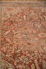 Low-angle view of a distressed Ahar carpet's worn texture and curvilinear floral patterns.