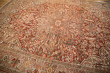Distressed texture on a vintage Ahar carpet's curvilinear medallion with red and charcoal floral details.