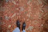 Distressed Heriz rug detail: visible texture, geometric florals in madder red, slate blue, gold.