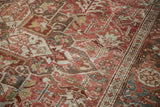 Vintage distressed Heriz carpet showing intricate raspberry, beige, and blue patterns with soft, worn texture.