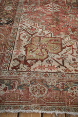 Distressed Heriz carpet detail, showing time-softened raspberry, sand, and dusty teal geometric patterns.