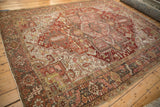 Distressed Heriz carpet border with geometric patterns and abrash in brick red, charcoal, lime green.
