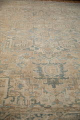 Distressed Heriz rug detail showing worn geometric patterns in sand and dusty blue.