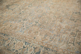 Distressed Heriz carpet detail showing geometric blossoms and soft beige with dusty blue.