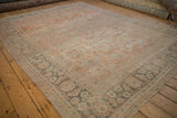 Low angle view of a distressed Mahal carpet, highlighting its soft texture and worn floral design.