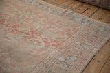Worn texture on the meandering vine border of a distressed Persian Mahal carpet.