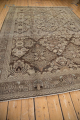 Low perspective across the vintage Bibikabad rug's worn floral pattern in brown and platinum.