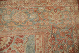 Worn texture on the corner of a vintage Mahal carpet with floral motifs in red and powder blue.