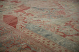 Evenly worn texture of a distressed Mahal carpet in cinnabar red, dusty blue, and ivory tones.