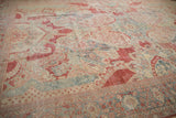 Evenly worn texture of a distressed Mahal carpet showing its red, blue, and ivory floral design.
