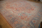 Detailed Karaja-style border with serrated leaves on a distressed vintage Heriz carpet.