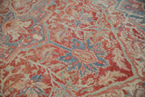 Detailed texture of the vintage Heriz carpet's distressed pile with powder blue and cinnabar red palmettes.