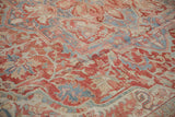 Distressed low pile texture of a vintage Heriz carpet showing serrated leaves in cinnabar red and powder blue.