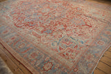 Corner of a distressed Heriz rug highlighting the detailed Karaja style border in red and powder blue.