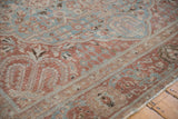 Distressed Tabriz carpet corner showing low pile texture in faded plum, sky blue, and beige.
