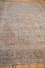 Low angle perspective showing the distressed texture and Safavid-inspired border of a vintage Tabriz rug.