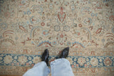 A view looking down at the distressed vintage rug's low pile and scrolling palmettes.
