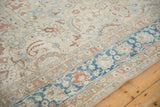 Corner detail of a vintage Persian Meshed carpet showing the low-pile texture and sapphire blue border.