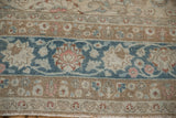 Worn knot heads of the Persian carpet's floral border in sapphire blue and copper.