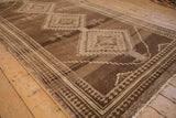 Distressed chocolate brown and cream Kars rug border with reciprocating pawn design.