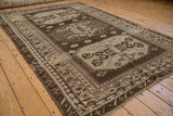 Angled view of a distressed Turkish Kars carpet highlighting its bold geometric medallions.