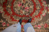 Vintage Khotan carpet's brightly colored fuchsia and green floral blossoms on cherry red.