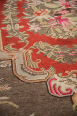 European-influenced curvilinear border and vibrant floral motifs on cherry red vintage Khotan pile.
