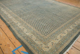 Distressed vintage Mir Sarouk rug corner showing worn dusty teal boteh and beige border.