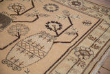 Vase with germinating plant motif on a distressed Khotan rug in sandalwood and greige tones.