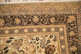 Corner detail of a vintage Kaisary carpet's intricate floral borders in chocolate brown and sand.