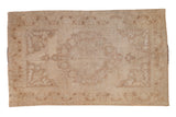 Vintage distressed Oushak carpet with a scalloped medallion over an abrashed beige and dusty gold field.